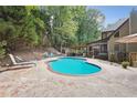 Relaxing kidney-shaped pool with patio, surrounded by trees at 2505 Ridgehurst Dr, Buford, GA 30518