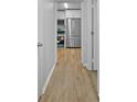 Hallway view towards a kitchen, featuring stainless steel appliances and modern design at 132 Arnold Pl, Jonesboro, GA 30236