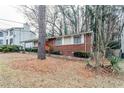 Brick ranch home with red door and mature trees surrounding at 2848 Baker Ridge Nw Dr, Atlanta, GA 30318