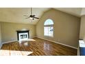 Spacious living room featuring hardwood floors, a fireplace, and a vaulted ceiling at 256 Kings Cv, Locust Grove, GA 30248