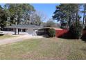 A single-story home with a manicured lawn, carport, and fenced backyard at 1988 Glenmar Dr, Decatur, GA 30032