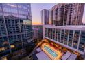 An aerial view showcasing a rooftop pool with lounge chairs and umbrellas, surrounded by city buildings at 40 12Th Ne St # 1701, Atlanta, GA 30309
