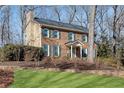 Brick and siding two-story house with green shutters and landscaping at 4187 Westchester Ne Trce, Roswell, GA 30075