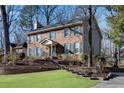 Brick and siding two-story house with green shutters and landscaping at 4187 Westchester Ne Trce, Roswell, GA 30075