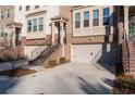 Townhouse exterior with brick facade, attached garage, and stairs at 372 Provenance Dr, Sandy Springs, GA 30328