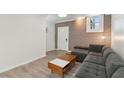 Basement living room with gray sectional sofa and exposed brick wall at 856 Briarcliff Ne Rd # 25, Atlanta, GA 30306