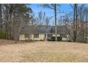 Charming single-story home with yellow siding, mature trees, and inviting front entrance at 4741 W Lake Se Dr, Conyers, GA 30094