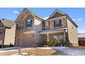 Two-story house with gray and stone accents, two-car garage, and a partially snow-covered front yard at 53 Cottontail Ln, Loganville, GA 30052