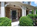 Inviting front entrance with a black door, landscaping, and a covered porch at 5540 Fords Crossing Nw Ct, Acworth, GA 30101