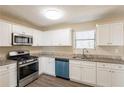 Bright kitchen featuring white cabinets, stainless steel appliances, granite counters, and wood-look flooring at 4547 Doral Sw Dr, Atlanta, GA 30331