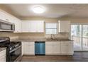 Bright kitchen featuring white cabinets, stainless steel appliances, granite counters, and wood-look flooring at 4547 Doral Sw Dr, Atlanta, GA 30331