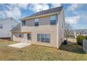 Tan house back with a patio, yard, and partial view of neighboring houses at 508 Cascade Walk, Mcdonough, GA 30253