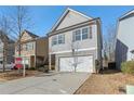 Two-story house with gray siding, white garage door, and landscaping at 1592 Jacobs Way, Stone Mountain, GA 30083