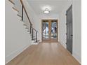 Light and airy entryway with hardwood floors and modern staircase at 2910 Caney Parc Way, Cumming, GA 30041