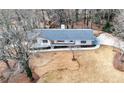 Aerial view of a renovated home with a long driveway in a wooded neighborhood at 1412 Dallas Sw Cir, Marietta, GA 30064