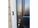 Close-up of a black front door with digital lock and brass handle at 1963 White Top Rd., Lawrenceville, GA 30045