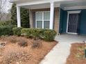 Front porch with brick columns, dark teal door, and neatly trimmed shrubs at 4338 Braden Nw Ln, Kennesaw, GA 30144