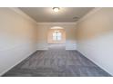 Bright living room featuring neutral paint, crown molding, and an archway leading to the dining area at 3535 Clarecastle Dr, Buford, GA 30519