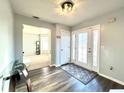 Bright entryway with glass front door, wood-look floors, and a view to the living room at 3877 Oakman Pl, Fairburn, GA 30213