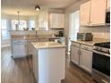 Modern kitchen with granite countertops, gray cabinets, and a large island at 3877 Oakman Pl, Fairburn, GA 30213