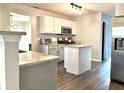 Modern kitchen with granite countertops, gray and white cabinets, and an island at 3877 Oakman Pl, Fairburn, GA 30213