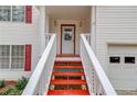 Front entry with red stairs and white railings leading to the front door at 93 Highway 81, Oxford, GA 30054