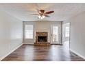 Living room featuring a stone fireplace and dark brown laminate flooring at 93 Highway 81, Oxford, GA 30054