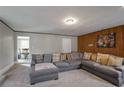 Inviting living room featuring a sectional sofa, wood paneling, and neutral color palette at 1619 Ridgeview Nw Dr, Conyers, GA 30012