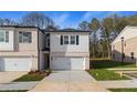 A modern townhome featuring a pristine white garage door and classic design elements at 329 Shine Dr, Stockbridge, GA 30281