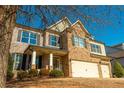 Two-story house with stone and brick accents, two-car garage, and landscaping at 5390 Chestnut Dr, Cumming, GA 30040