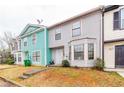 Quaint townhome featuring pastel colors, concrete walkway, and well-manicured lawn at 1023 Thornwoode Ln, Stone Mountain, GA 30083