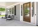 Covered porch with two wicker chairs and a side view of the front door at 510 Oak Dr, Hapeville, GA 30354
