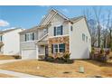 Two-story house with gray siding, stone accents, and a two-car garage at 251 Ivy Chase Loop, Dallas, GA 30157