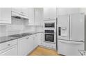 Modern white kitchen featuring granite countertops and stainless steel appliances at 211 Colonial Homes Nw Dr # 1105, Atlanta, GA 30309