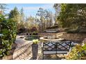 Stone patio with a circular pool and spa, surrounded by lush landscaping at 6229 Grand Loop Rd, Sugar Hill, GA 30518