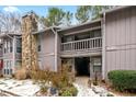 Gray condo building with stone fireplace and snowy landscaping at 4037 Woodridge Way, Tucker, GA 30084