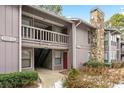 Gray condo building with stone fireplace and snowy landscaping at 4037 Woodridge Way, Tucker, GA 30084