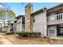 Gray condo building with stone fireplace and landscaping at 4037 Woodridge Way, Tucker, GA 30084