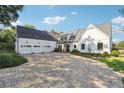 White farmhouse with a large paved driveway and attached three-car garage at 3842 Ernest W Barrett Sw Pkwy, Marietta, GA 30064