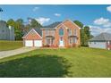 Brick house with a two-car garage and a well-maintained lawn at 93 Carriage Lake Dr, Stockbridge, GA 30281