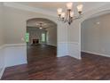 Dining room with dark wood floors, arched doorways, and a view into the living room at 459 Benson Meadows Dr, Dallas, GA 30157