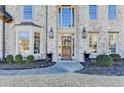 Elegant front entry with brick facade and wood door at 3350 Vista Creek Dr, Dacula, GA 30019