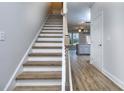 Modern staircase with light wood treads and white risers, leading to the upper level at 6166 Ripple Way # 79, South Fulton, GA 30349