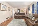 Living room with hardwood floors, brown sofas, and a view of the staircase at 1980 Campfire Dr, Riverdale, GA 30296