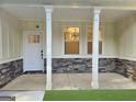 Front porch showcasing stone accents, white pillars, and a classic door with natural light at 485 N Oakland Circle, Mcdonough, GA 30253