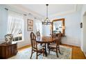 Bright dining room features hardwood floors, a chandelier, and an elegant wood table with chairs at 1440 Vinery Ave, Cumming, GA 30041