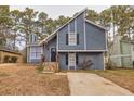 Gray house with stone accents and a paved driveway, nestled among trees at 6300 Creekford Dr, Lithonia, GA 30058