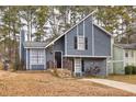 Gray house with stone accents and a paved driveway, nestled among trees at 6300 Creekford Dr, Lithonia, GA 30058