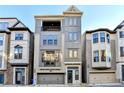 Three-story townhome with gray siding, two-car garage, and balcony at 606 Broadview Ne Ter, Atlanta, GA 30324