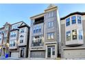 Three-story townhome with gray siding, two-car garage, and balcony at 606 Broadview Ne Ter, Atlanta, GA 30324